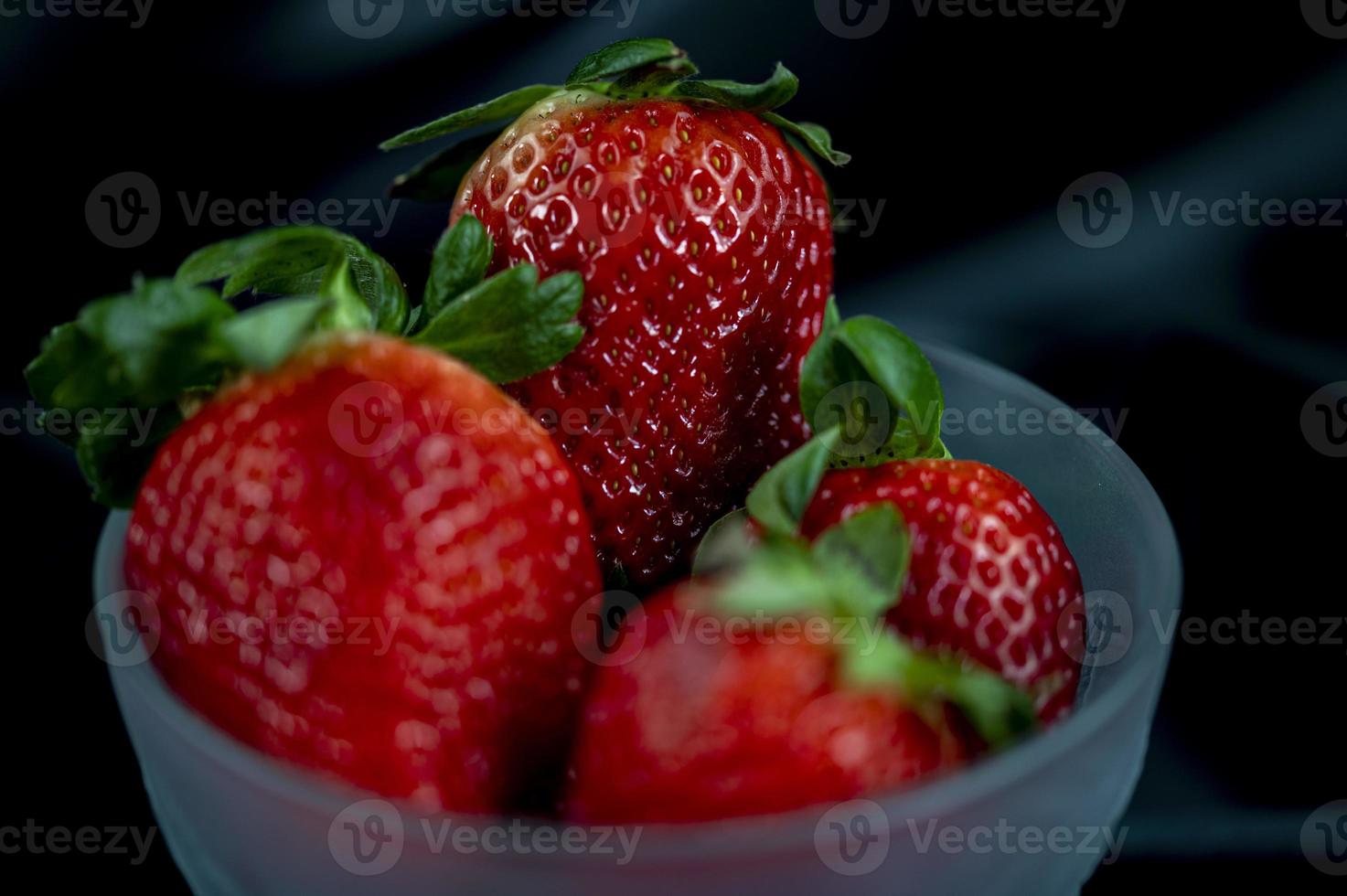 Tasse reife Erdbeeren auf schwarzem Hintergrund foto