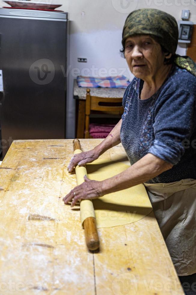 Oma rollt den frisch gekneteten Teig aus foto