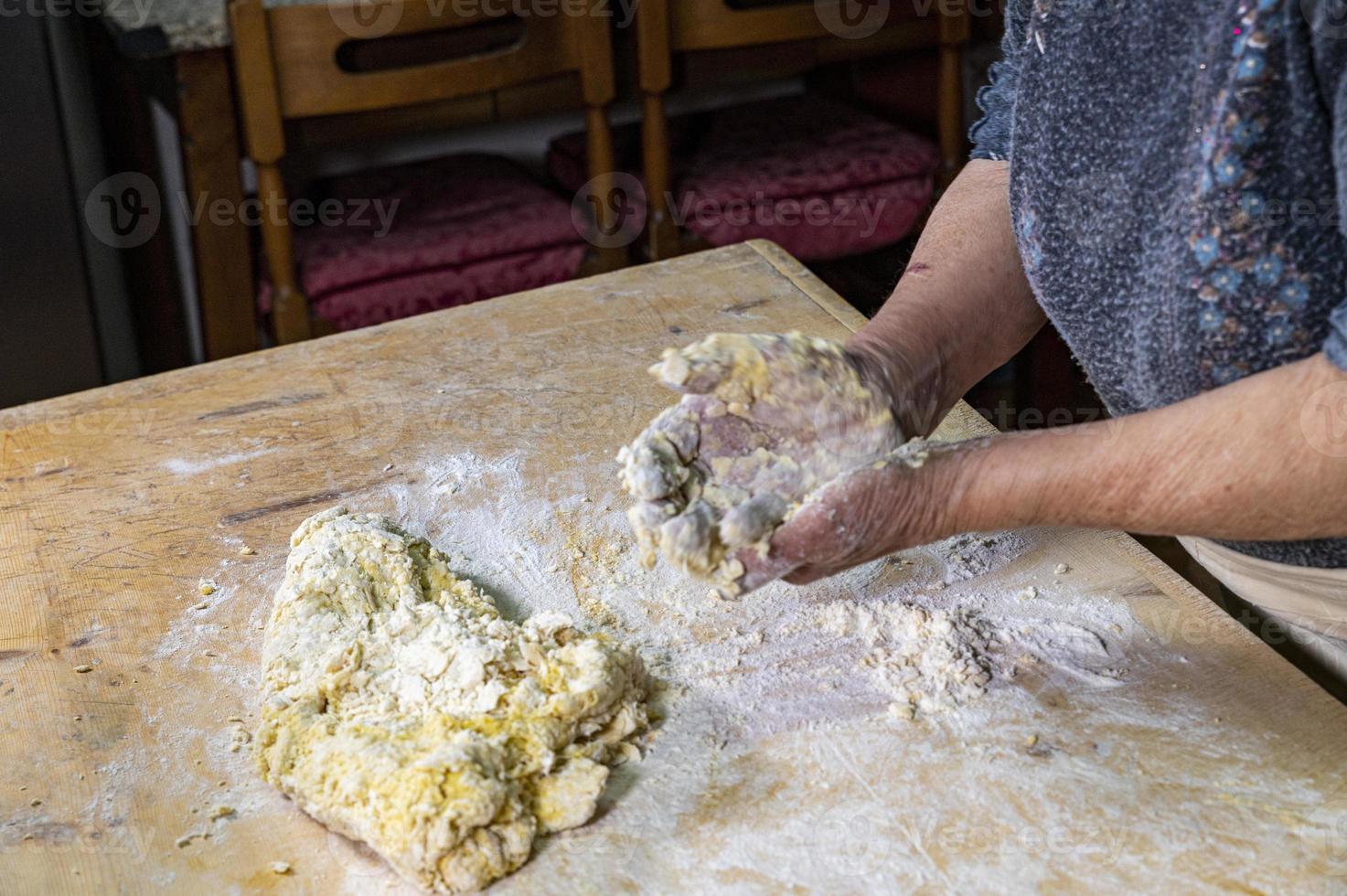 Oma bereitet hausgemachte Pasta zu foto