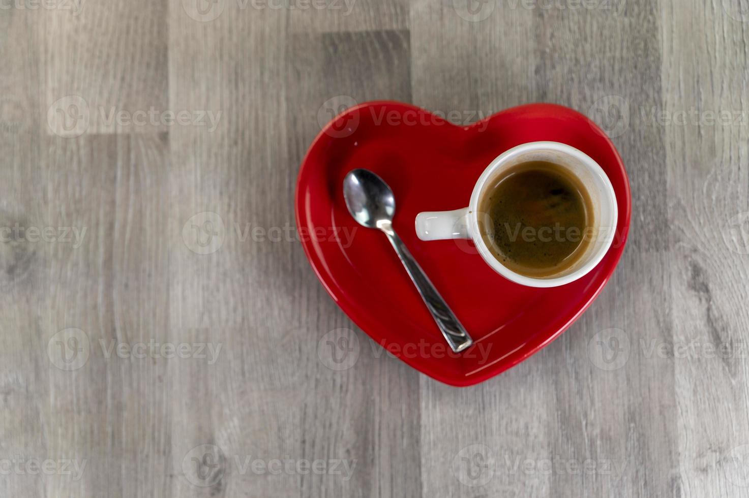 eine Tasse Kaffee mit einer herzförmigen Untertasse foto