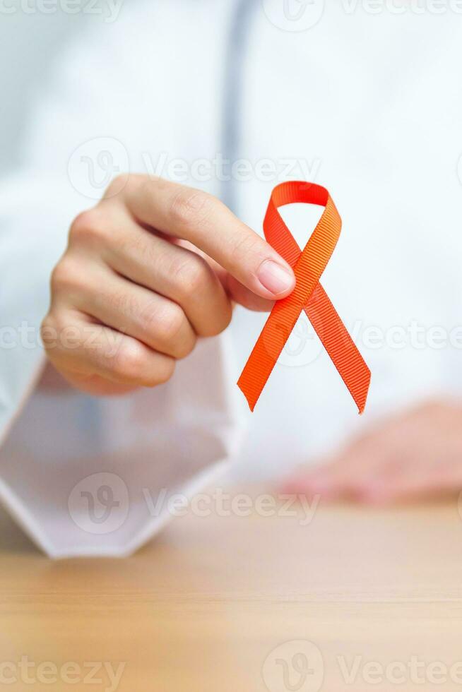 Arzt mit Orange Band zum Leukämie, Niere Krebs Tag, Welt mehrere Sklerose, crps, selbst Verletzung Bewusstsein Monat. Gesundheitswesen und Wort Krebs Tag Konzept foto