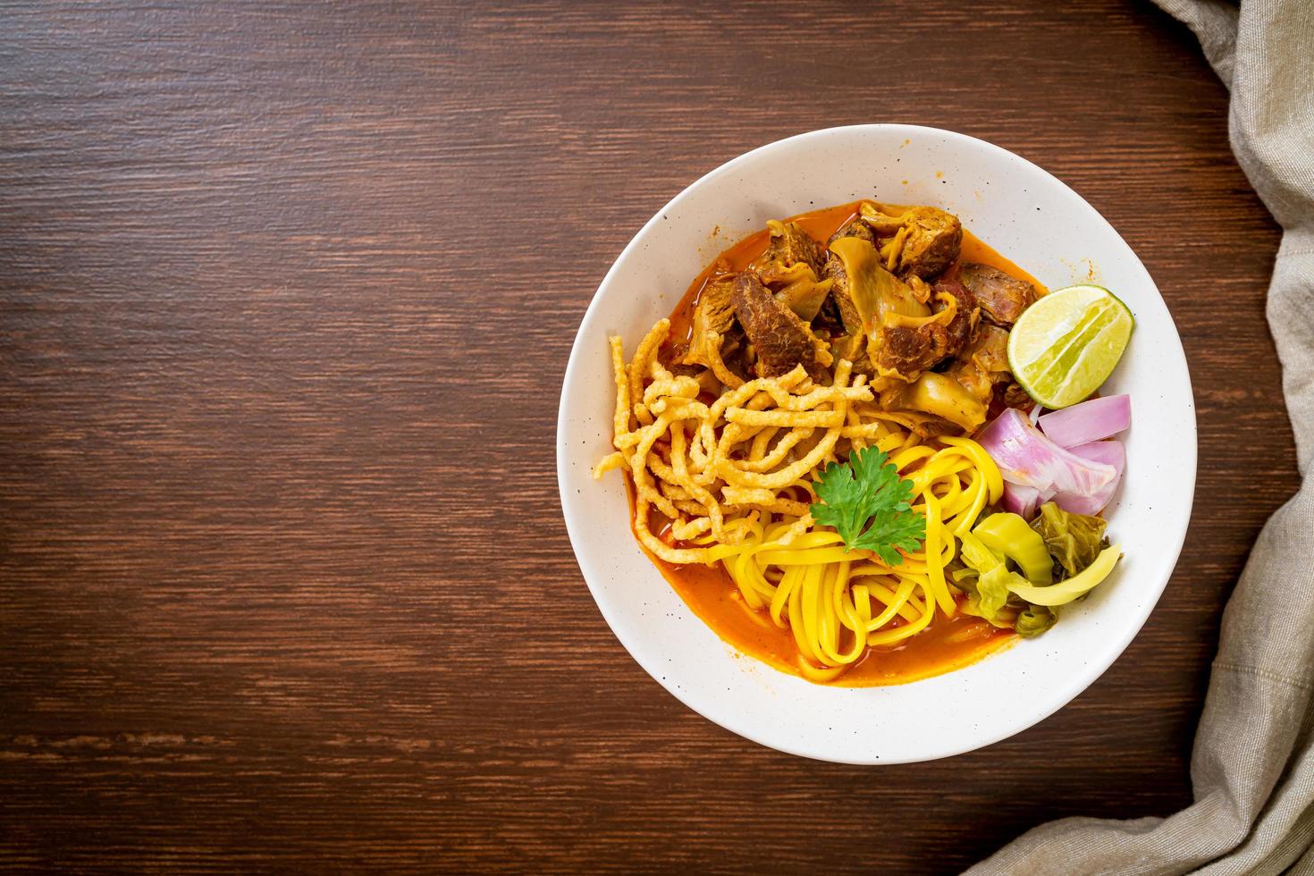 Nordthailändische Nudel-Curry-Suppe mit geschmortem Schweinefleisch foto