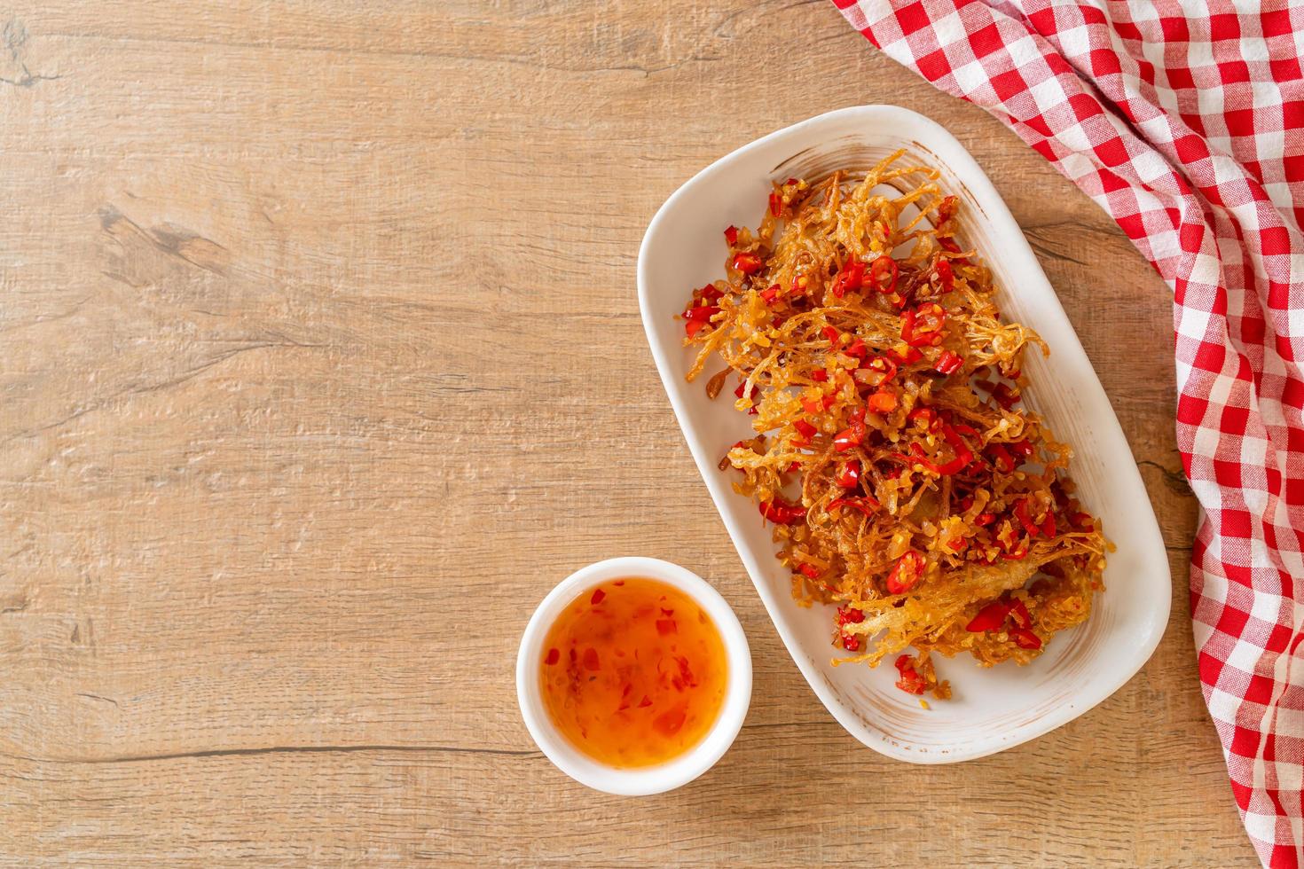 gebratener Enoki-Pilz oder goldener Nadelpilz mit Salz und Chili foto