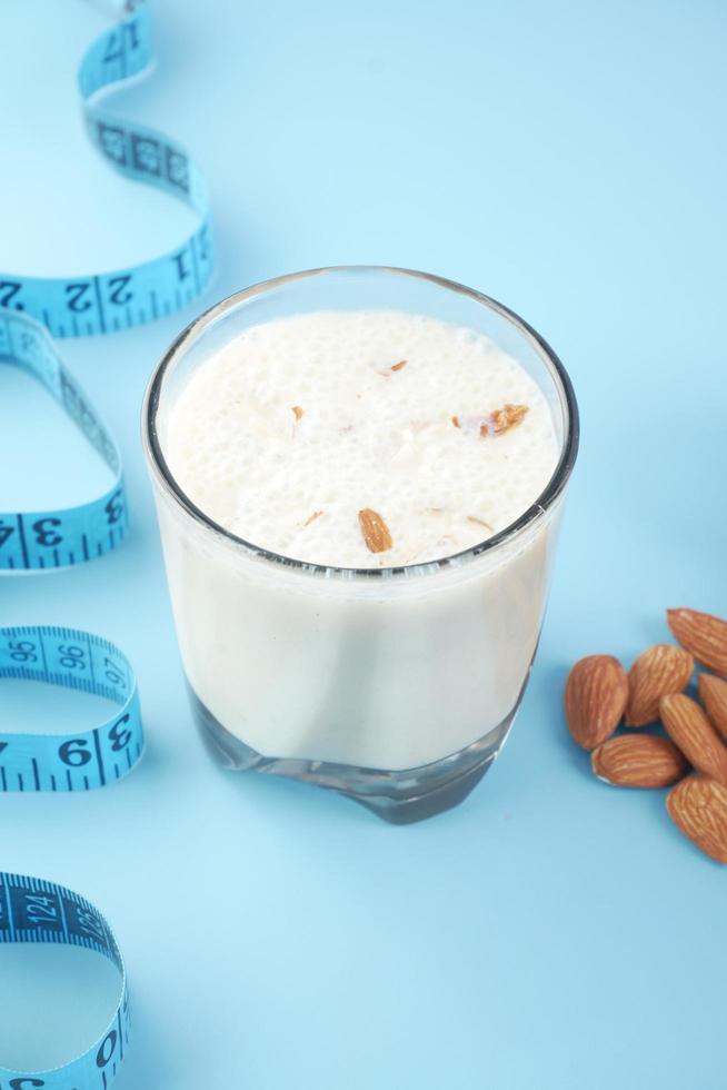 Maßband Mandelnuss und Milch auf blauem Hintergrund foto