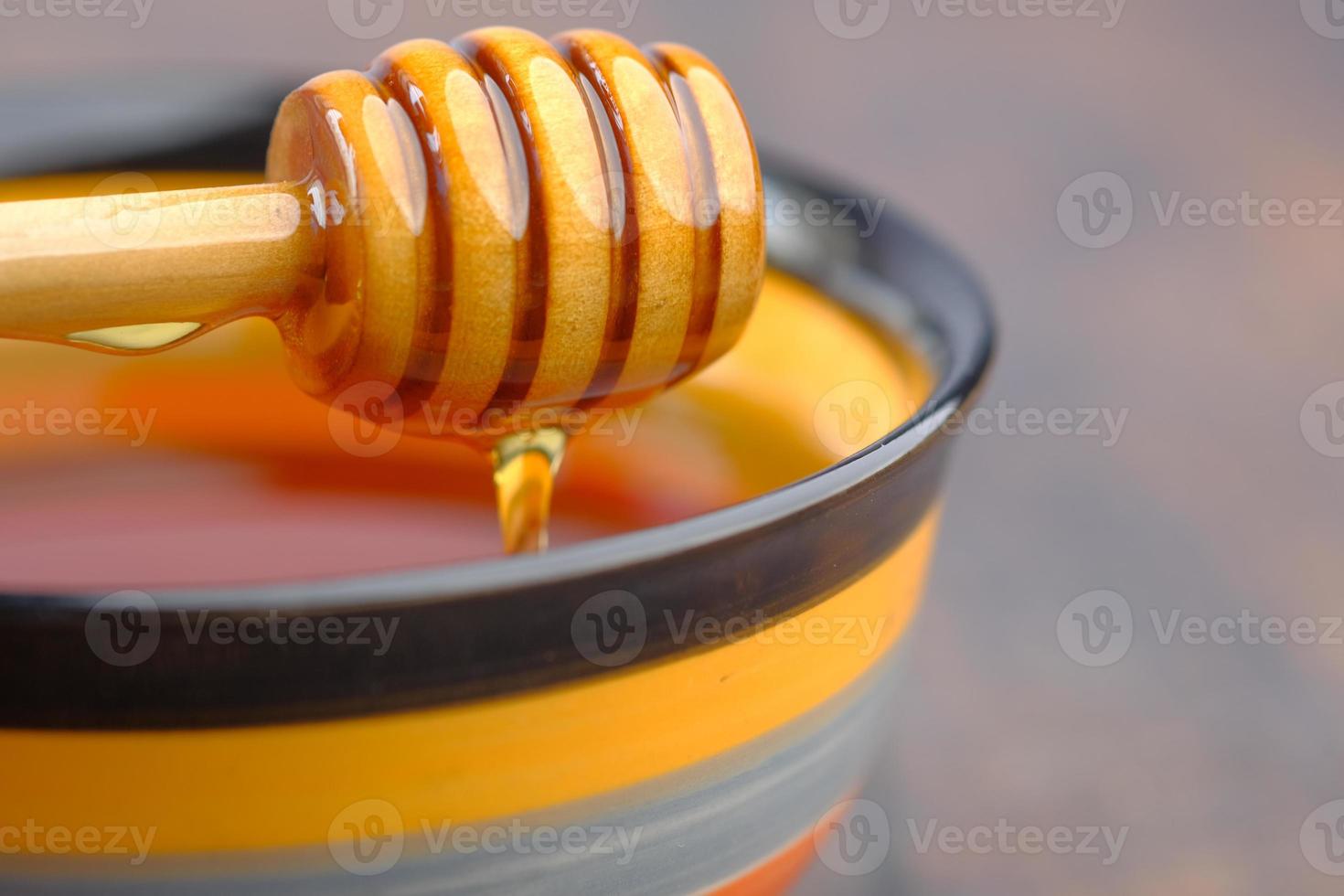 Nahaufnahme von frischem Honig mit Löffel auf dem Tisch foto