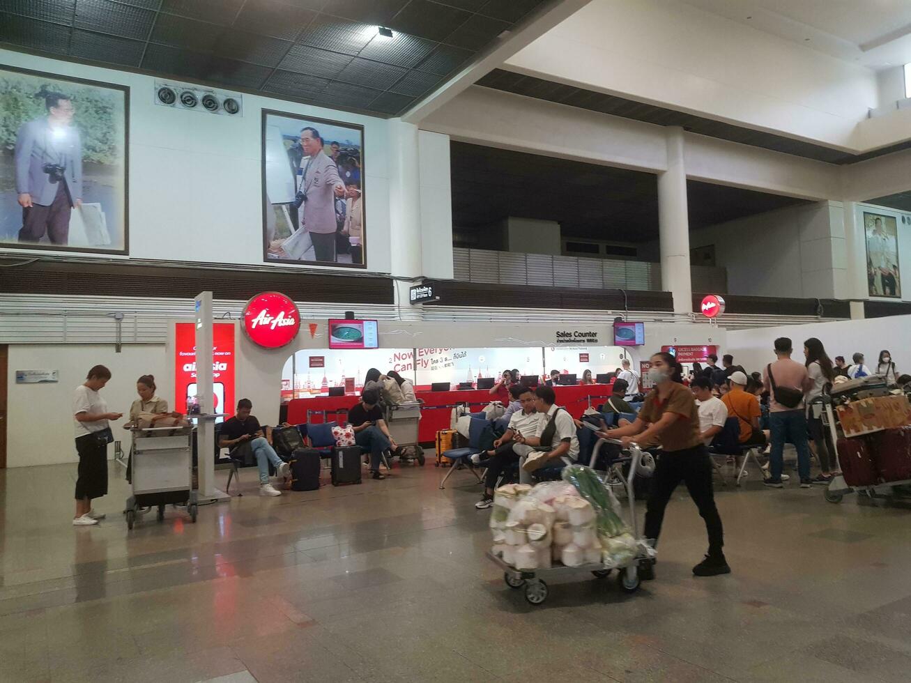 Bangkok, Thailand auf Juli 9, 2023. mehrere Menschen Sitzung im das warten Bereich von Terminal 1 von Bangkok Don mueang International Flughafen. foto