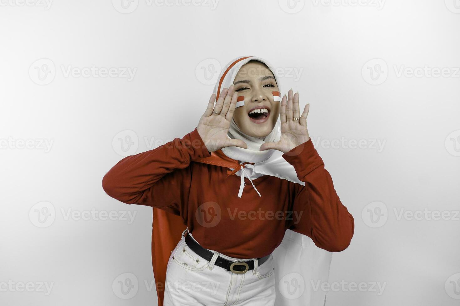 jung schön Muslim Frau tragen ein rot oben und Weiß Hijab ist halten Indonesiens Flagge und schreien und schreiend laut mit ein Hand auf ihr Mund. Indonesiens Unabhängigkeit Tag Konzept. foto