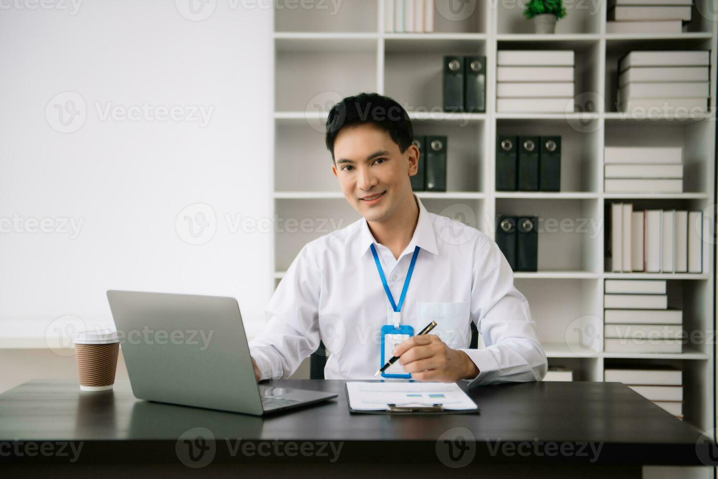 jung asiatisch Geschäft Mann mit Laptop und Tablette während Sitzung beim ihr Arbeiten Ort. konzentriert beim arbeiten. foto