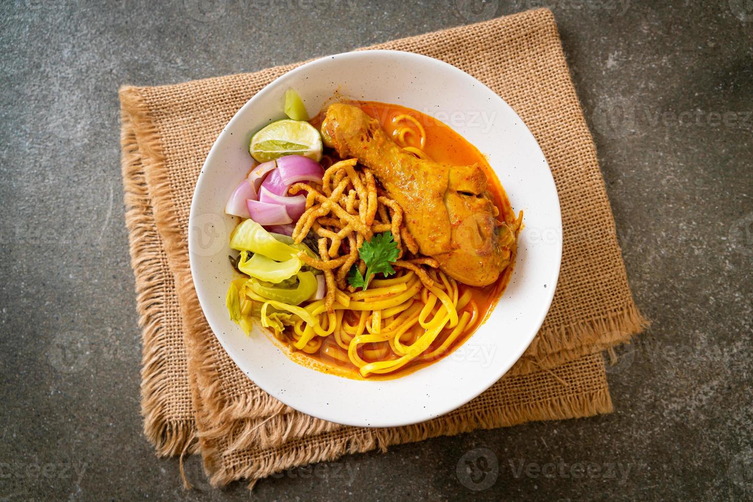 Nordthailändische Nudel-Curry-Suppe mit Hühnchen foto