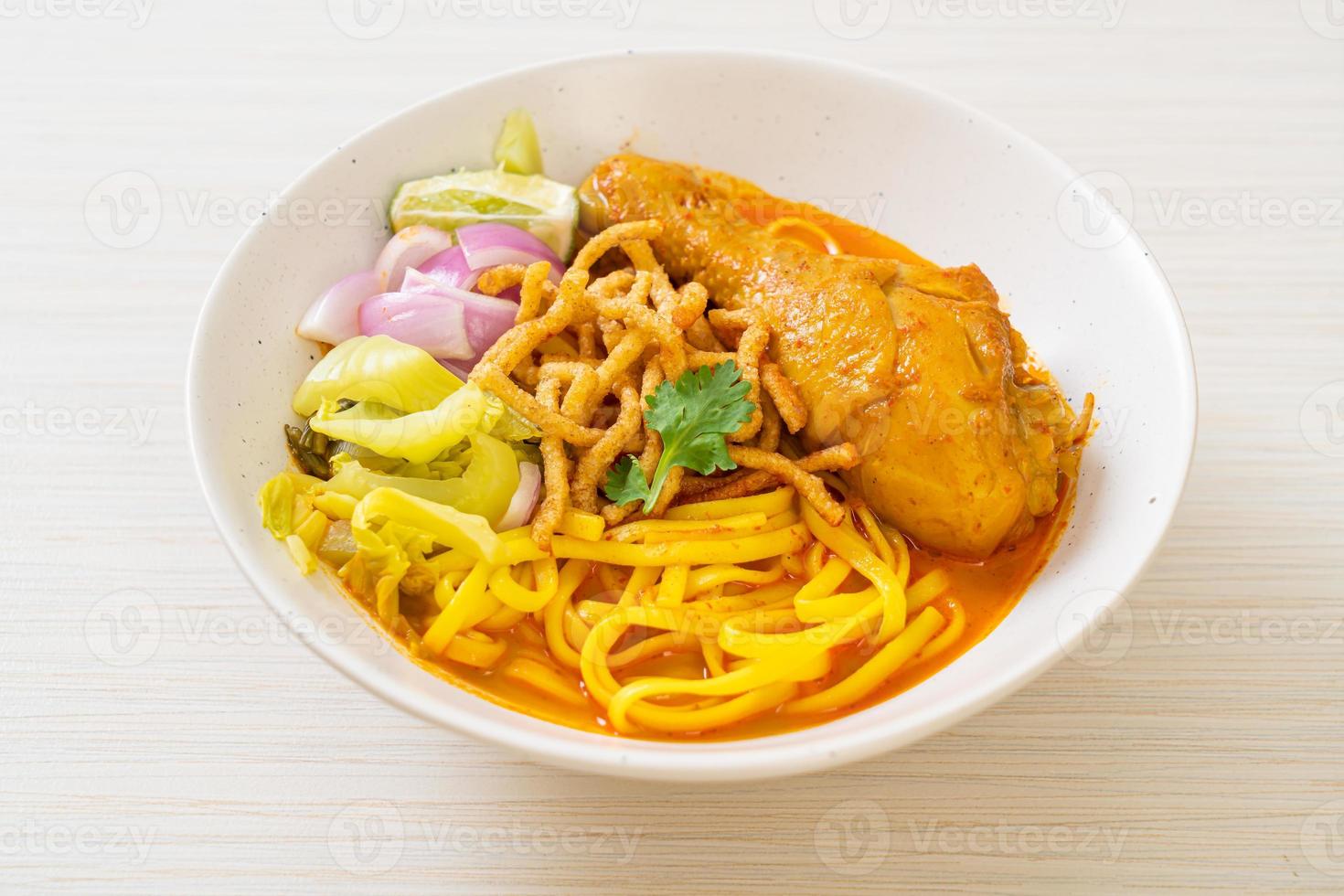 Nordthailändische Nudel-Curry-Suppe mit Hühnchen foto