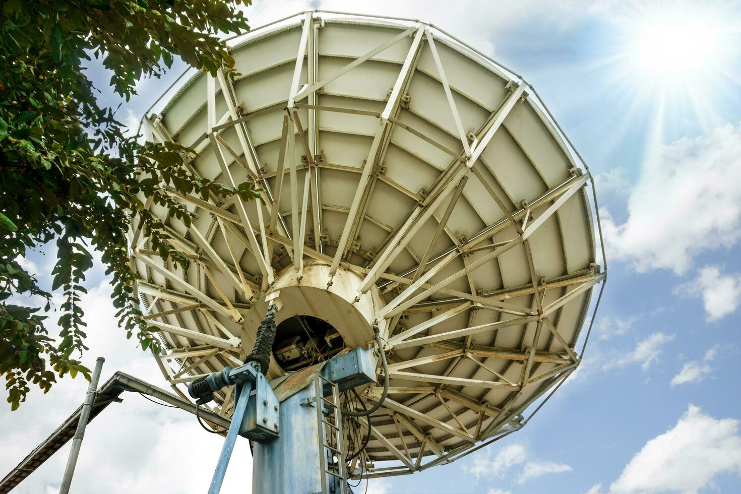 zurück Aussicht von großartig Satellit Gericht beim Fernseher Bahnhof unter hell Blau Himmel und Sonne Fackel Hintergrund. foto