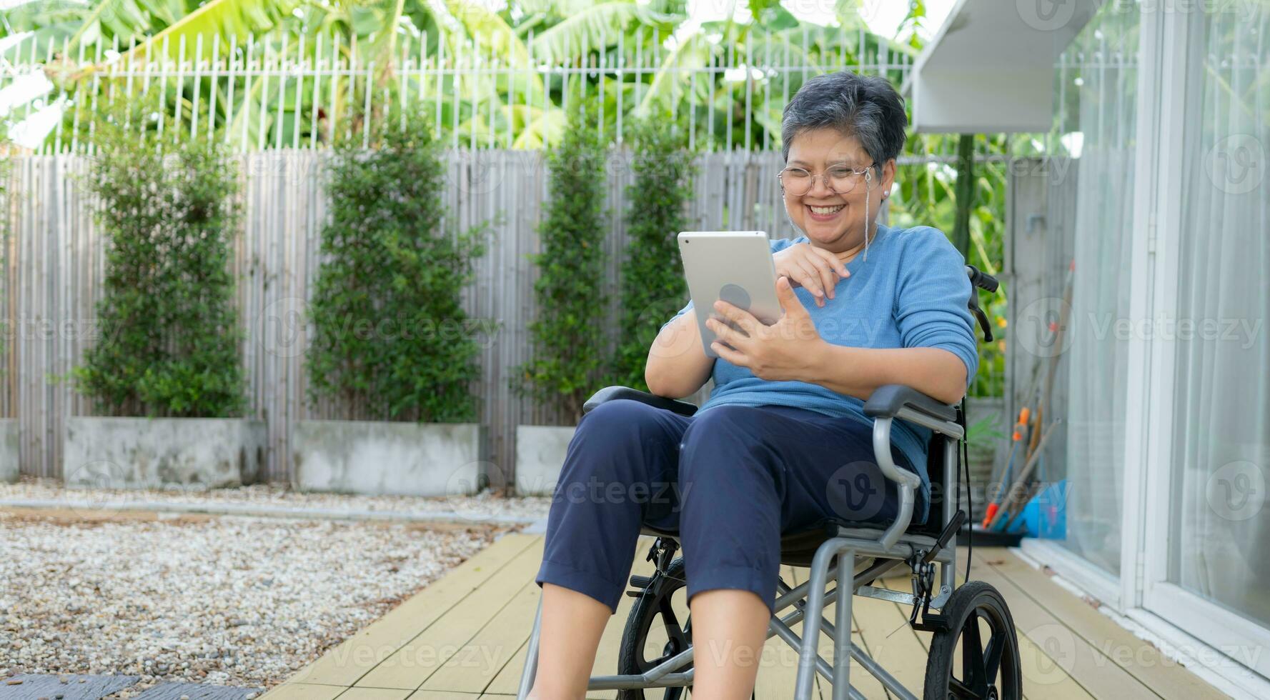 glücklich Senior Frau im Rollstuhl mit Digital Tablette beim heim. 27004449  Stock-Photo bei Vecteezy