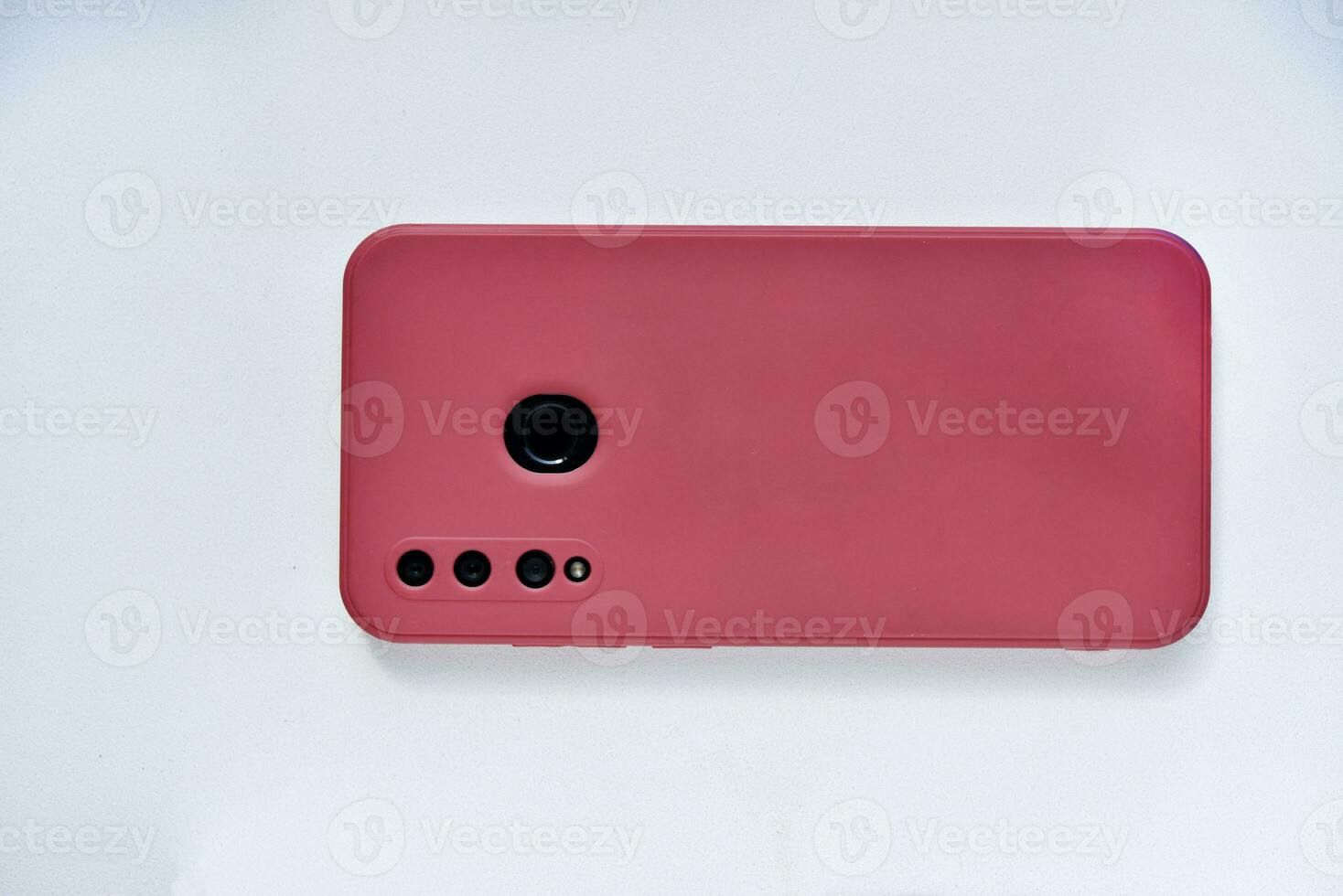 ein Smartphone im ein rot Fall auf das zurück Seite. Telefon Kamera. foto