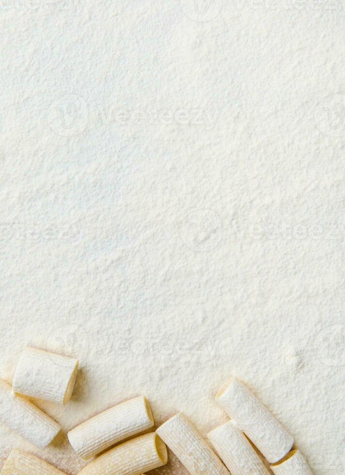 eben legen Komposition mit ganze Weizen Italienisch Pasta, Tortiglioni auf ein bemehlt Hintergrund mit Kopieren Raum zum Anzeige foto