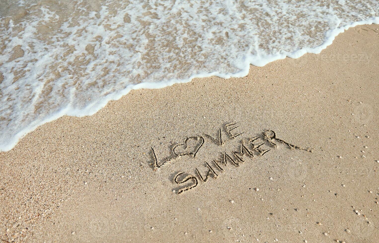 handgeschrieben Inschrift, Briefe, ich Liebe Sommer- auf das nass Sand auf das Hintergrund von das Meer Welle Waschen Weg mit Wasser. foto