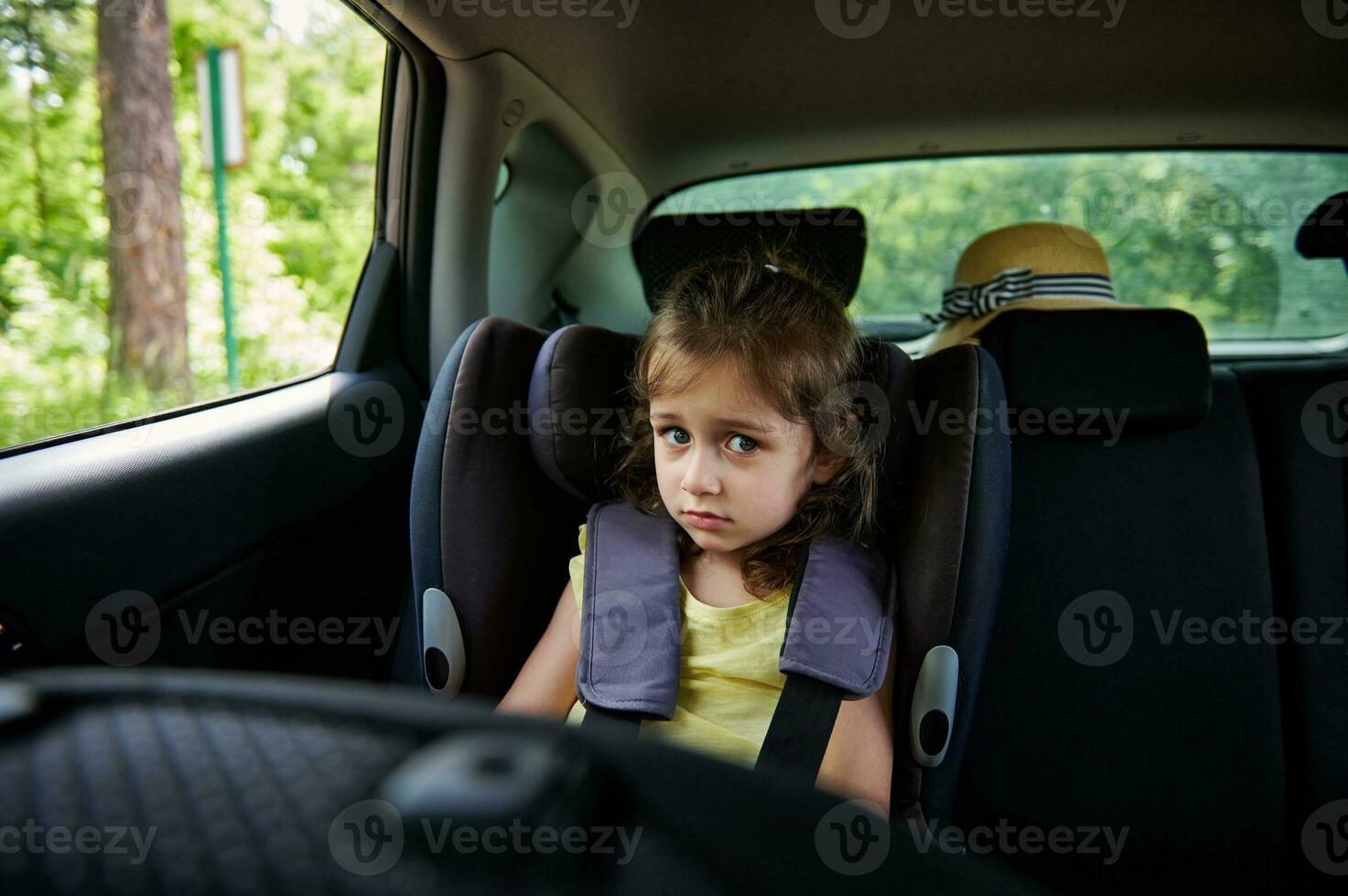 befestigt wenig Mädchen zu Kind Sicherheit Sitz Innerhalb Wagen. sicher Bewegung von Kinder im das Wagen. foto