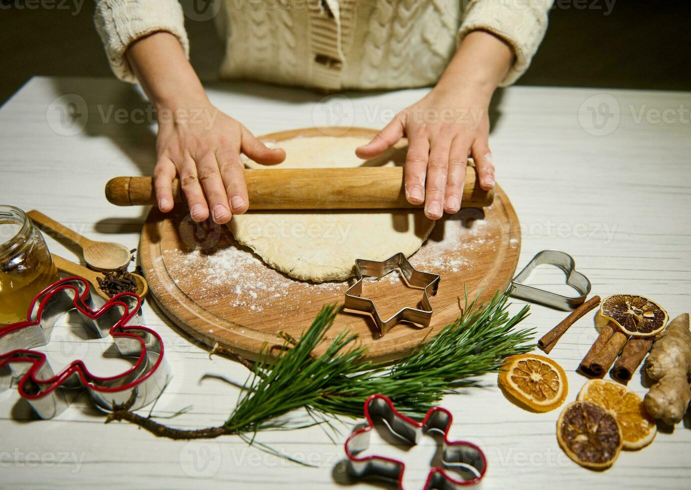unkenntlich Koch Frau rollen aus Teig mit ein rollen Stift auf ein hölzern Planke, vorbereiten Weihnachten Lebkuchen im das Küche. traditionell Veranstaltungen, Neu Jahre Feier Konzept foto