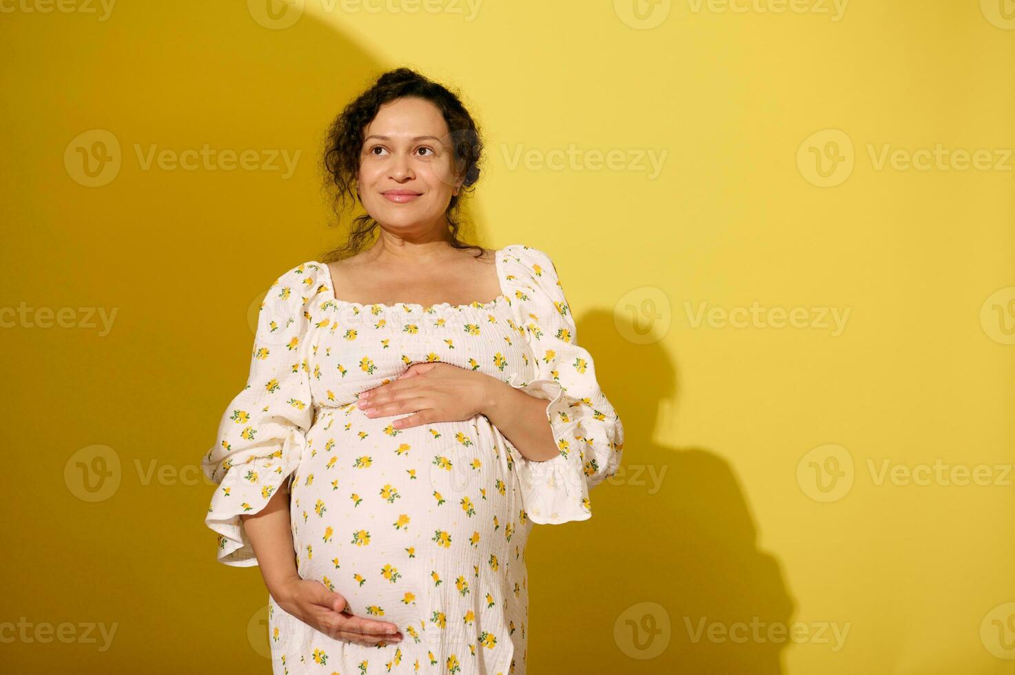 schwanger Frau halten Bauch, isoliert Gelb Studio Hintergrund foto