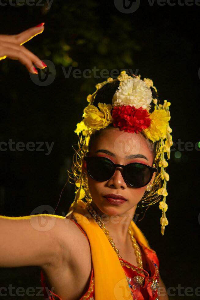 ein javanisch Tänzer Tänze sehr geschickt während tragen Sonnenbrille auf ihr Augen und sehr schön Gesichts- bilden foto