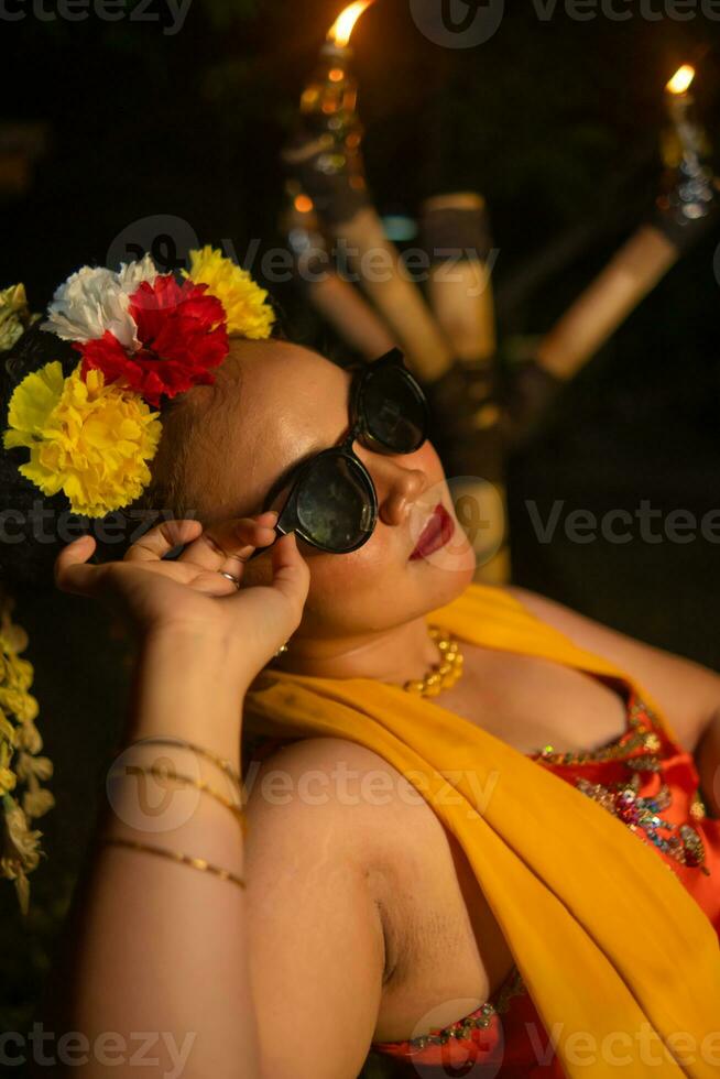 Porträt von ein Teenager Mädchen mit Sonnenbrille und ein ziemlich Blume posieren sehr schön foto