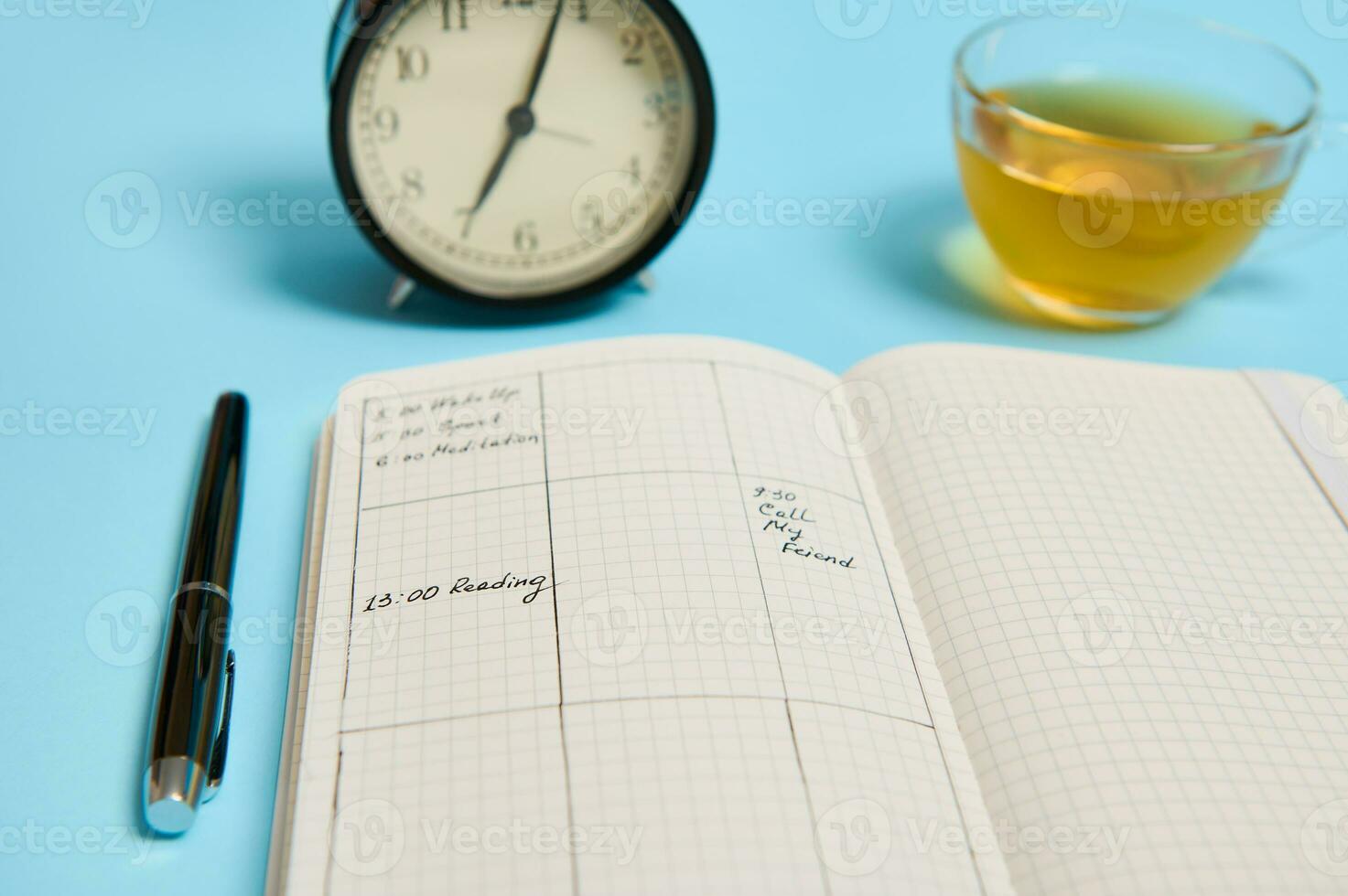 Zeit Management, Frist und Zeitplan Konzept. Alarm Uhr auf Zeitplan planen, Veranstalter mit Pläne, Tinte Stift und transparent Glas Tasse mit Tee auf Blau Hintergrund mit Raum zum Text foto