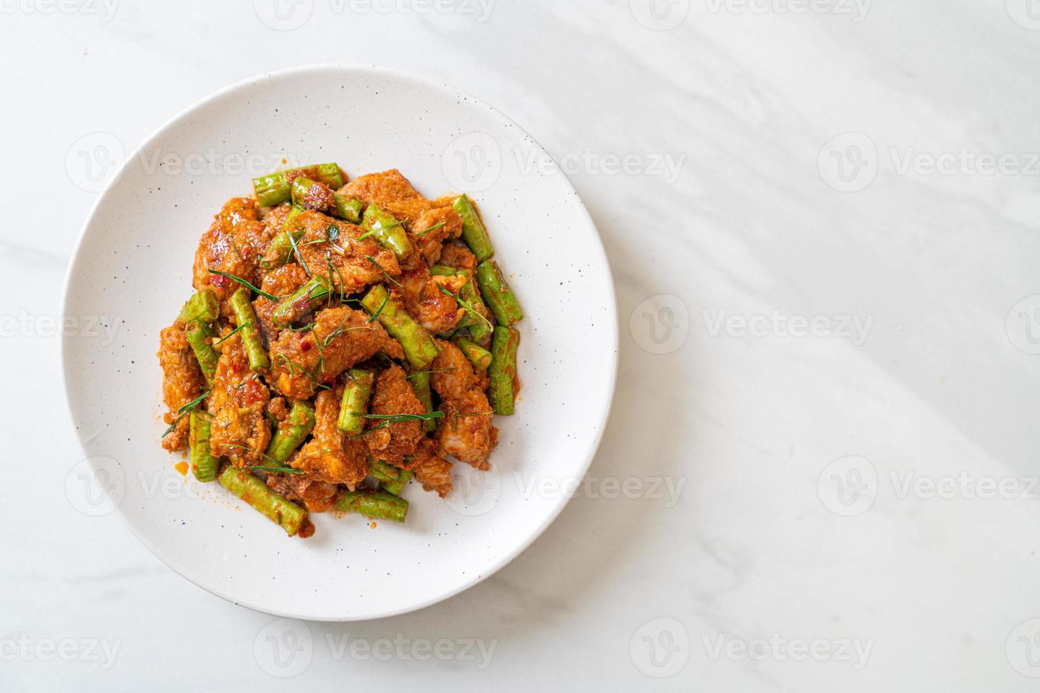 gebratenes Schweinefleisch und rote Currypaste mit Stachelbohnen rühren foto