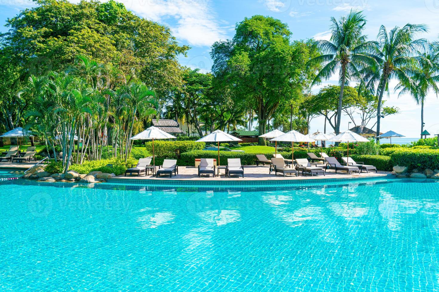 schöner Sonnenschirm und Stuhl um den Pool im Hotel und Resort? foto