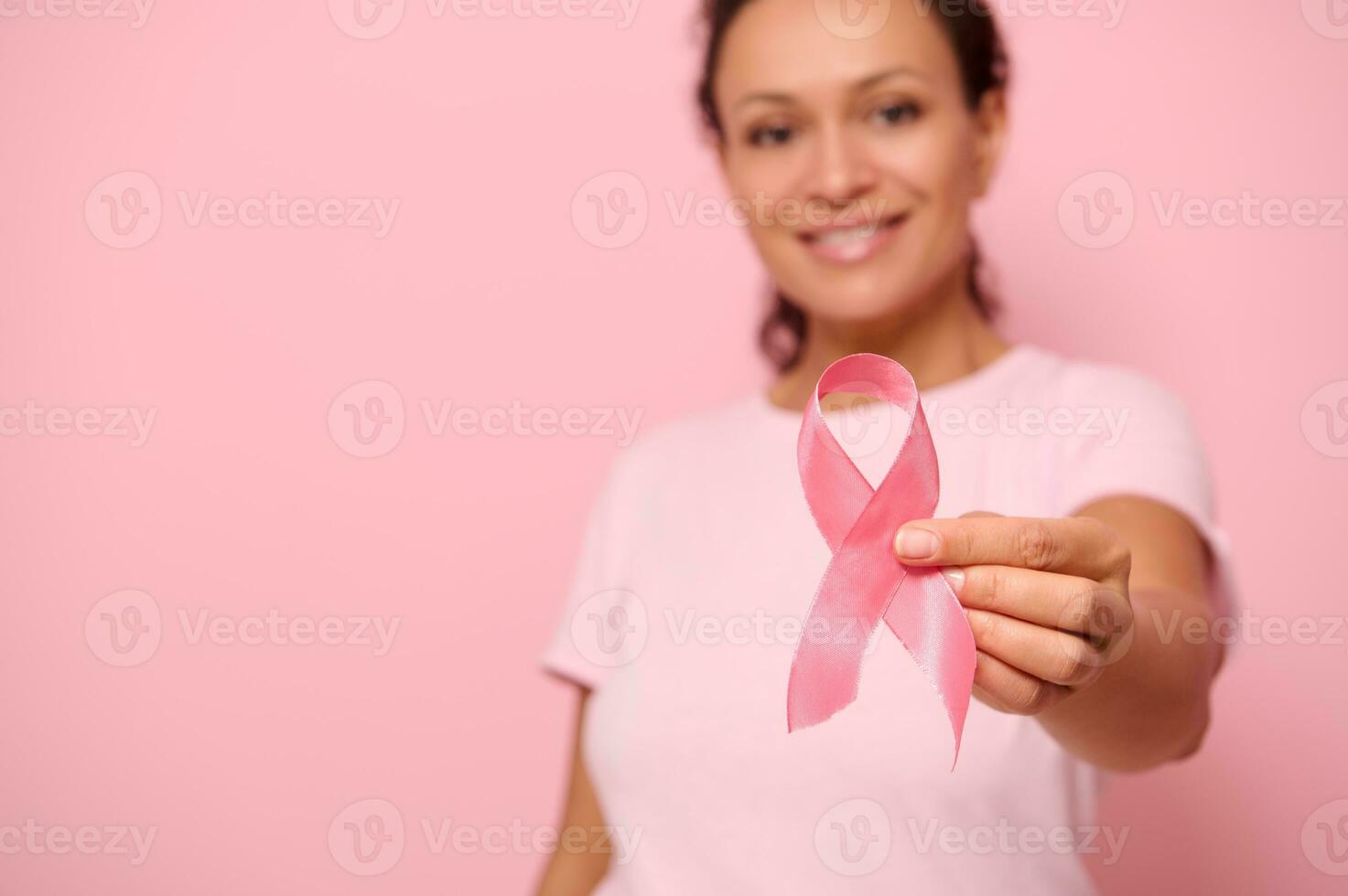 verschwommen lächelnd afrikanisch Frau im Rosa T-Shirt halten Satin- Band im ihr Hand. Brust und Bauch Krebs Bewusstsein, Oktober Rosa Tag auf farbig Hintergrund, Kopieren Raum. Brust Krebs Unterstützung Konzept foto