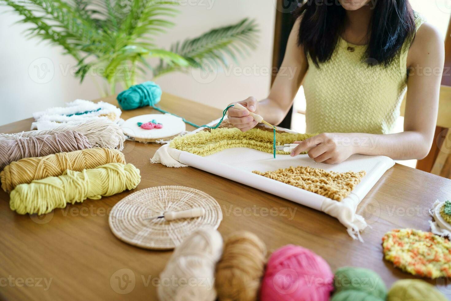 schlagen Nadel. asiatisch Frau Herstellung handgemacht Hobby Stricken im Studio Werkstatt. Designer Arbeitsplatz handgemacht Kunst Projekt DIY Stickerei Konzept. foto