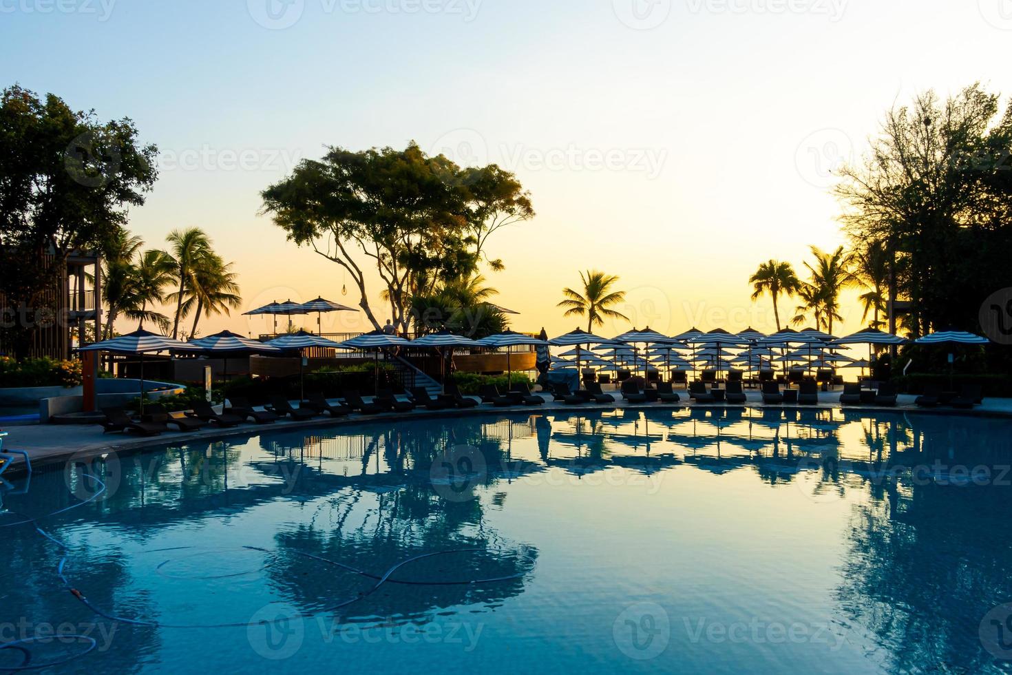 Sonnenschirm und Stuhlsofa rund um den Außenpool im Hotelresort für den Reiseurlaub? foto