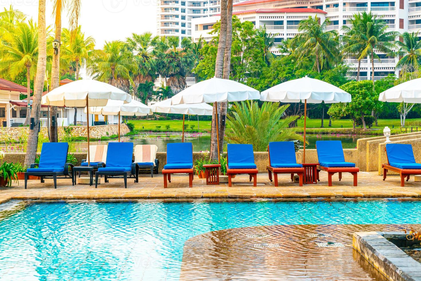 schöner Sonnenschirm und Stuhl um den Pool im Hotel und Resort? foto