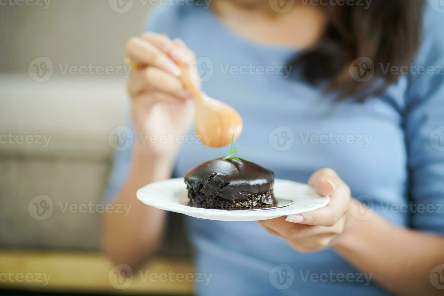 schön asiatisch Frau Essen lecker Schokolade Kuchen. Teen Mädchen Essen das Kuchen. foto