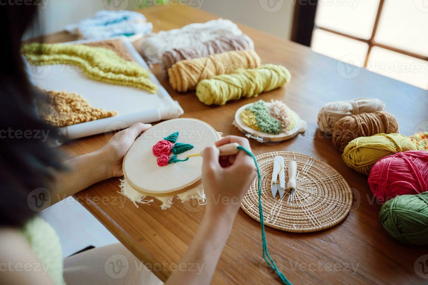 schlagen Nadel. asiatisch Frau Herstellung handgemacht Hobby Stricken im Studio Werkstatt. Designer Arbeitsplatz handgemacht Kunst Projekt DIY Stickerei Konzept. foto