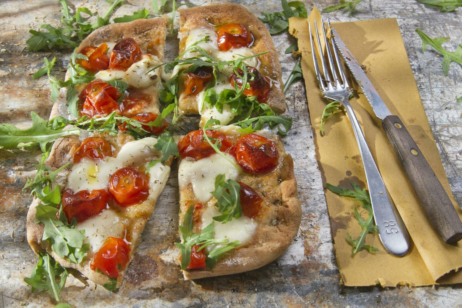 Pizza mit Tomaten und Rucola foto
