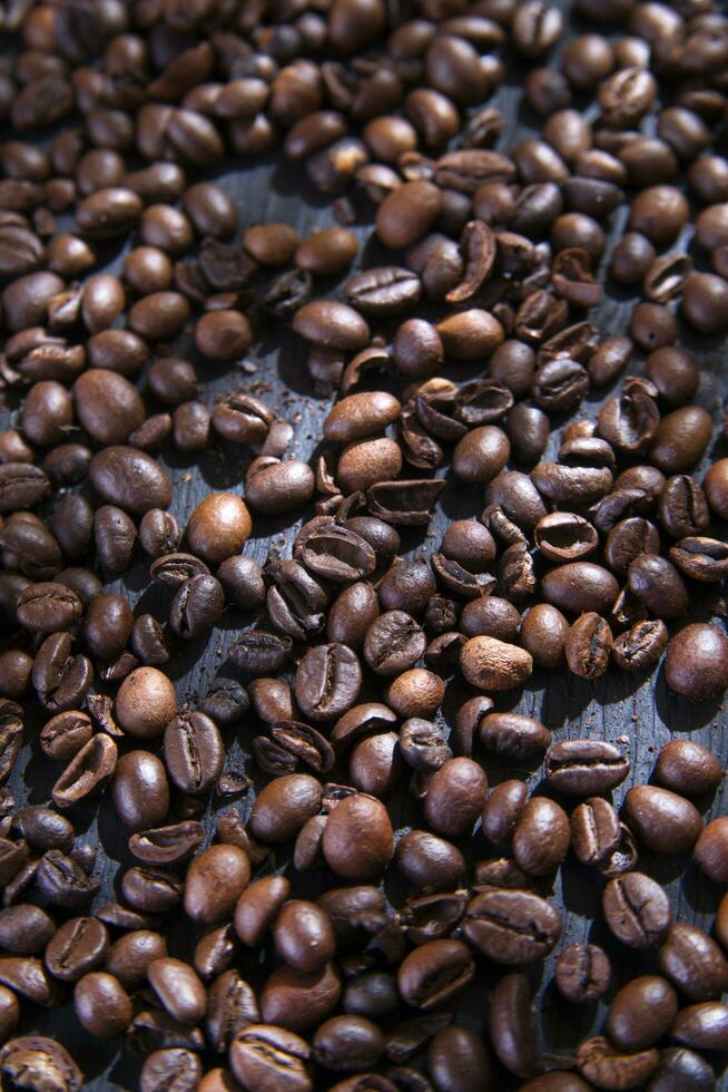 Kaffee Bohnen auf ein dunkel hölzern Tabelle foto