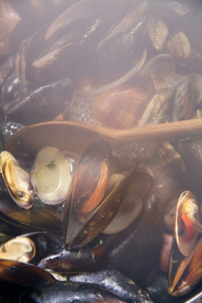 ein Schüssel von Muscheln mit Zitrone und Petersilie foto