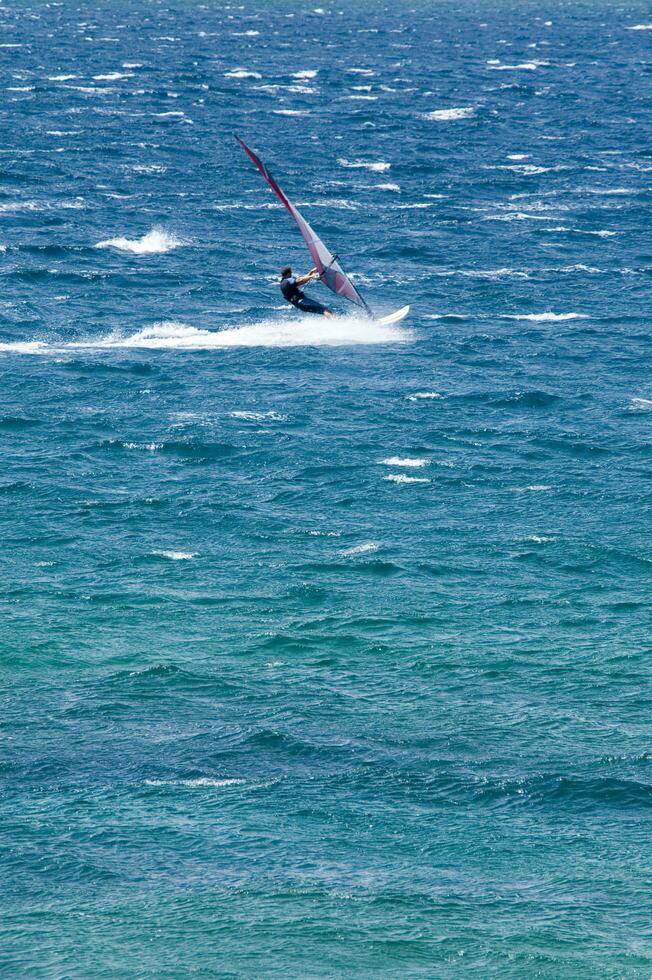 ein Mann Windsurfen im das Ozean foto