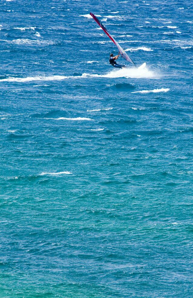 ein Mann Windsurfen im das Ozean foto