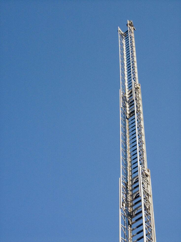 ein hoch Metall Turm mit ein Blau Himmel im das Hintergrund foto