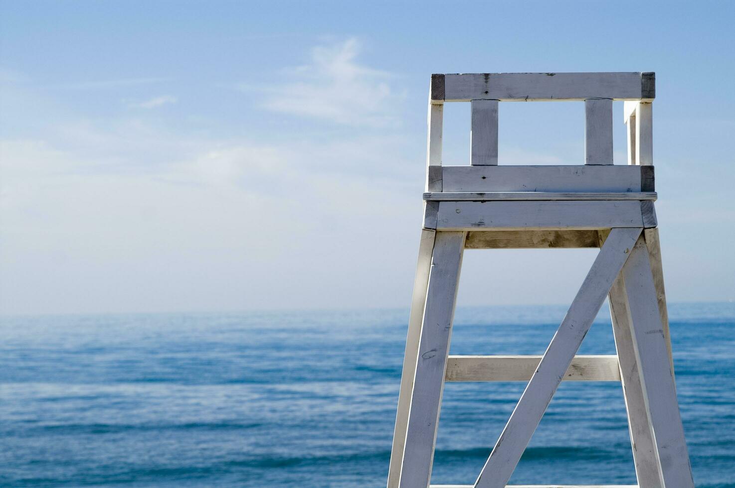 ein Rettungsschwimmer Stuhl Sitzung auf ein Strand foto