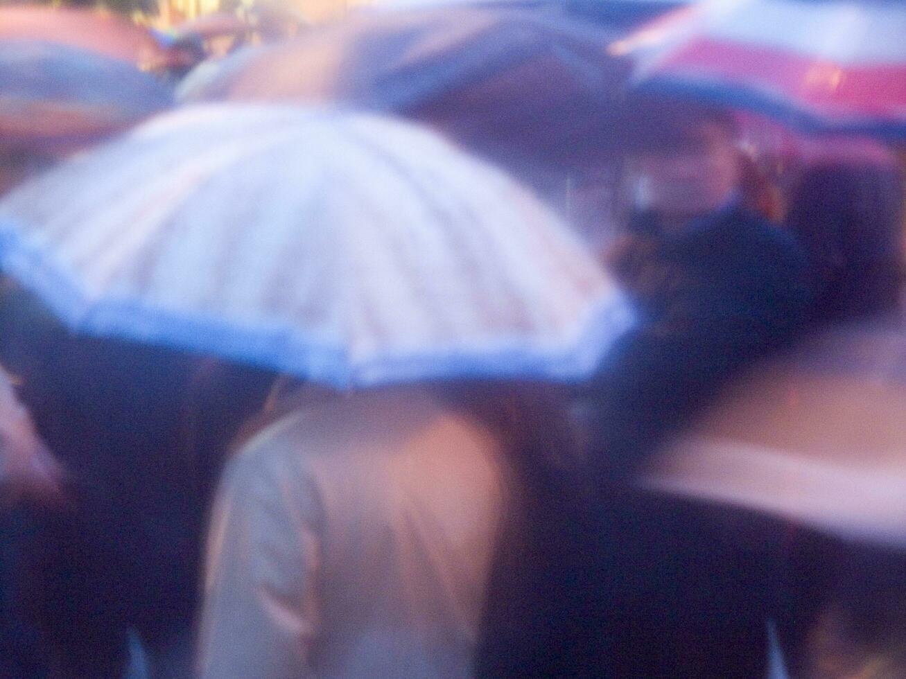 ein verschwommen Bild von ein Person halten ein Regenschirm foto