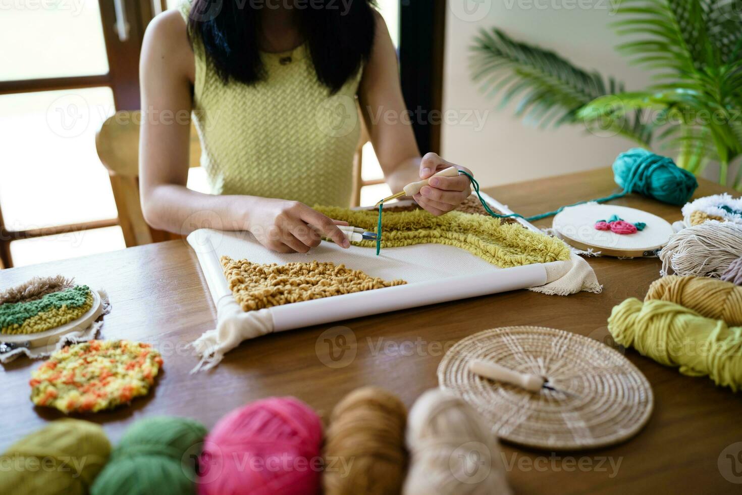 schlagen Nadel. asiatisch Frau Herstellung handgemacht Hobby Stricken im Studio Werkstatt. Designer Arbeitsplatz handgemacht Kunst Projekt DIY Stickerei Konzept. foto