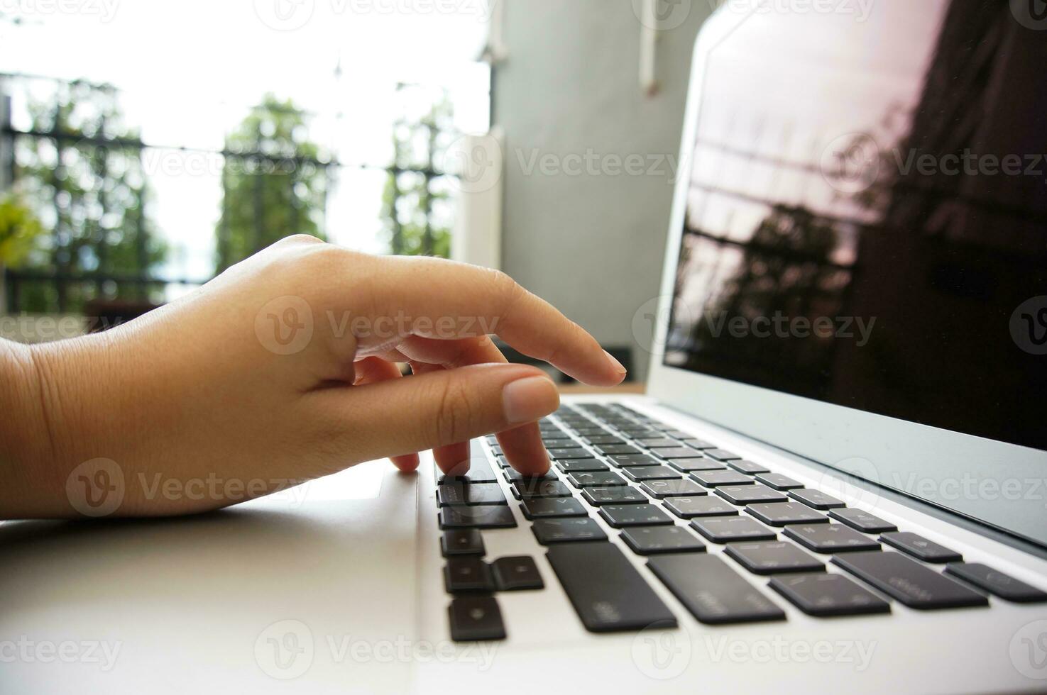 Arbeiten durch mit ein Laptop Computer auf hölzern Tisch. Hände Tippen auf ein Klaviatur. foto