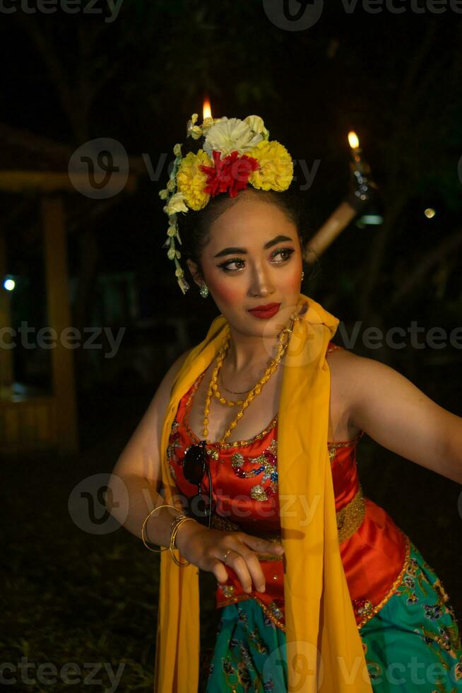 Porträt von ein traditionell Sundanesisch Tänzer Tanzen mit ein Orange Schal hängend Nieder ihr Körper foto