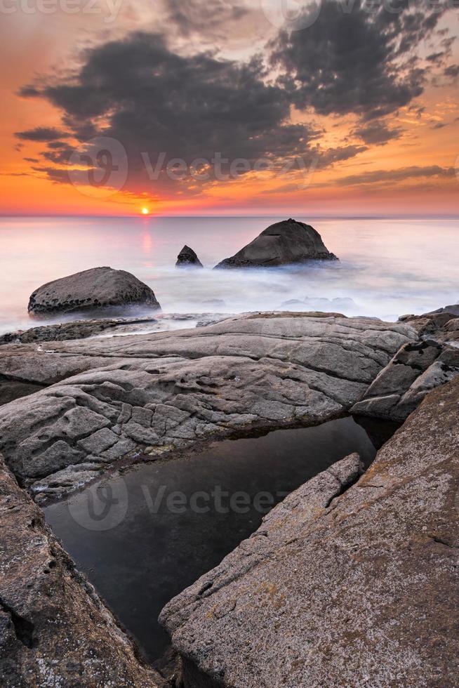 bewölkter Himmel und orangefarbener Sonnenuntergang am Strand foto