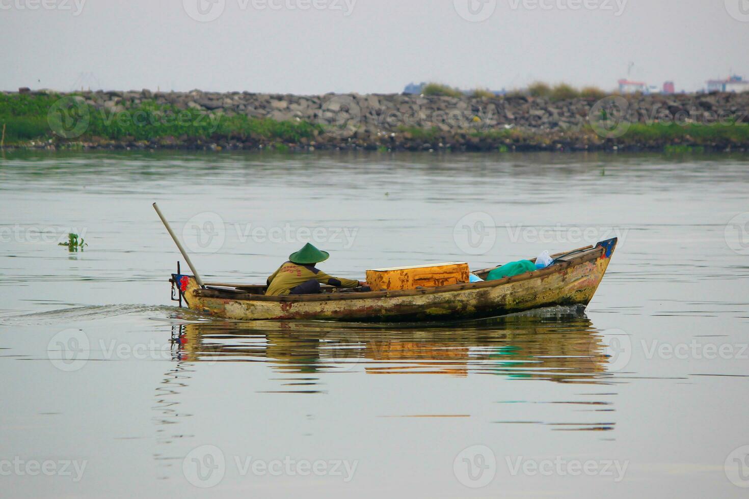 ein indonesisch Fischer ist Angeln auf ein Boot foto