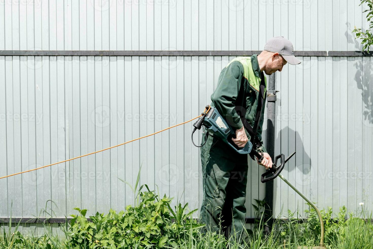 ein Mann mäht Rasen Gras mit ein Rasen Mäher. Benzin Rasen Mäher, Trimmer Nahansicht. Mann Arbeiten im das Garten foto