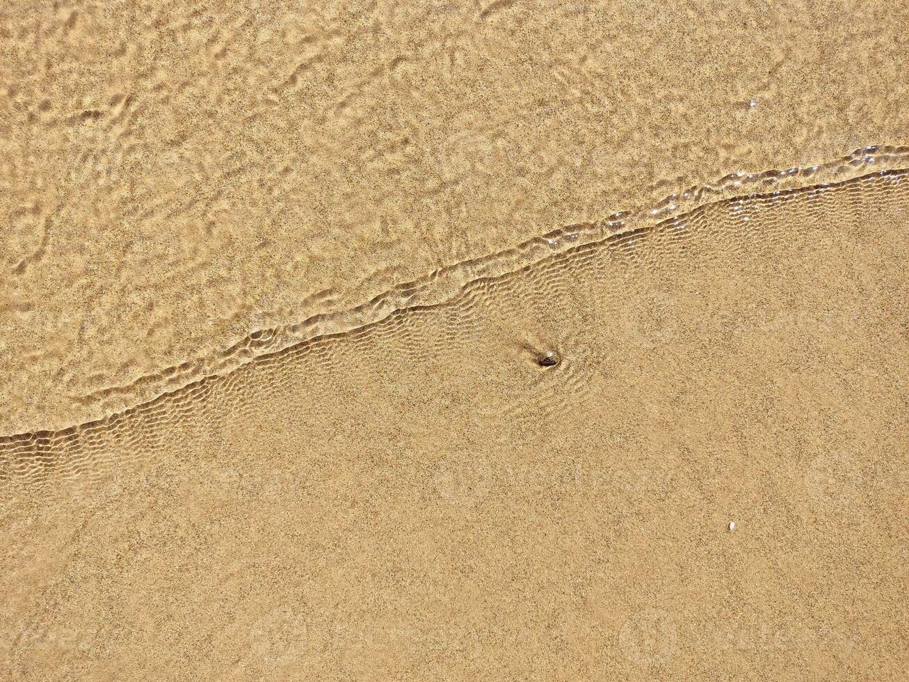 Strand nass Sand Textur. sandig Ufer Beige Hintergrund. foto