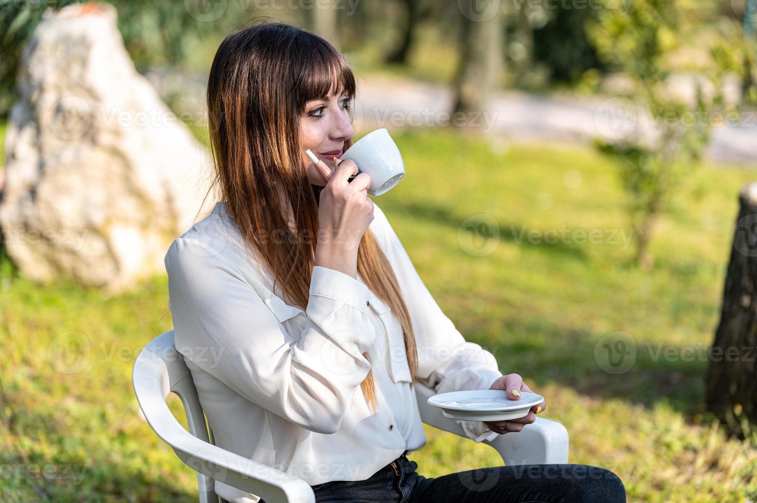 Mädchen trinkt eine Tasse Tee im Garten foto