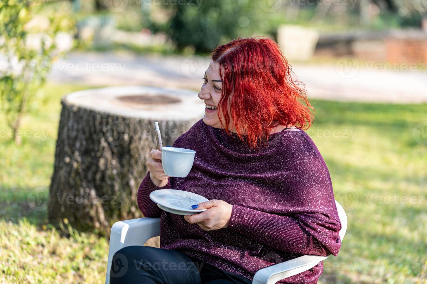 Mädchen trinkt eine Tasse Tee im Garten foto